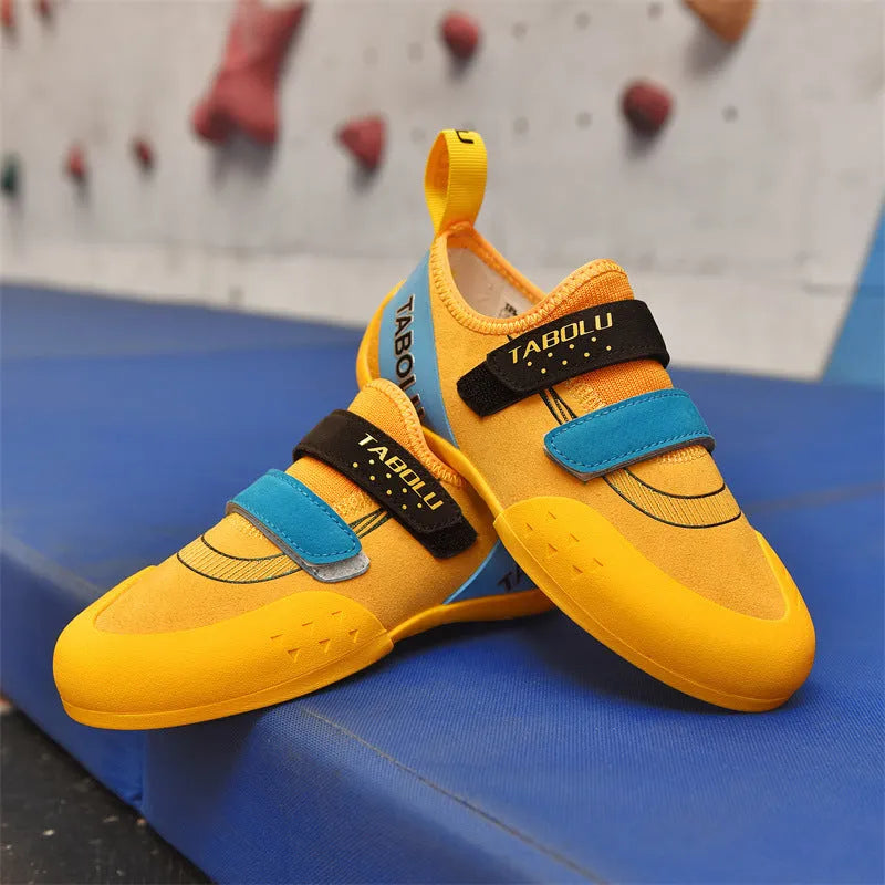 Beginner rock climbing shoes with Velcro strap and rubber sole in black and red colour.