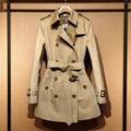 Khaki women's double breasted trench coat with flight sleeves and button detailing.