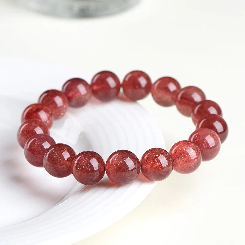 Natural cherry red strawberry quartz bracelet with geometric cut stones on wrist