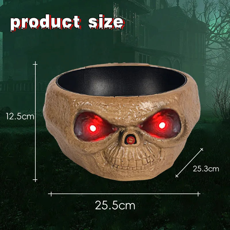 Plastic Halloween candy bowl with motion-activated skeleton hand and glowing red eyes on a table