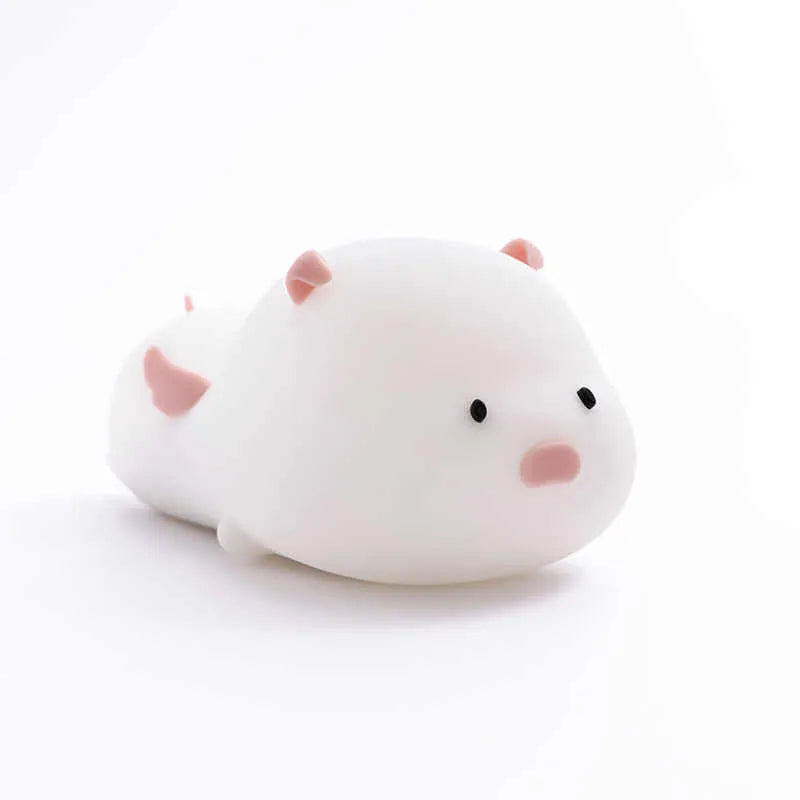 Cute pig silicone night light in Pink with sleeping face design on a wooden table