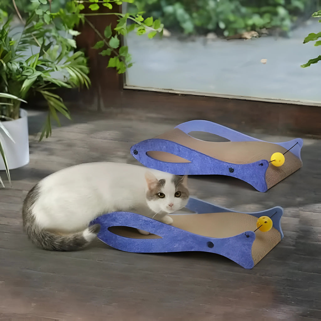 Blue fish shaped cat scratcher with cardboard surface and ball toy on elastic cord