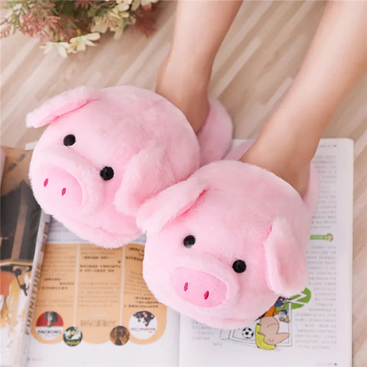 Pink pig-shaped plush floor slippers for adults on a white background.