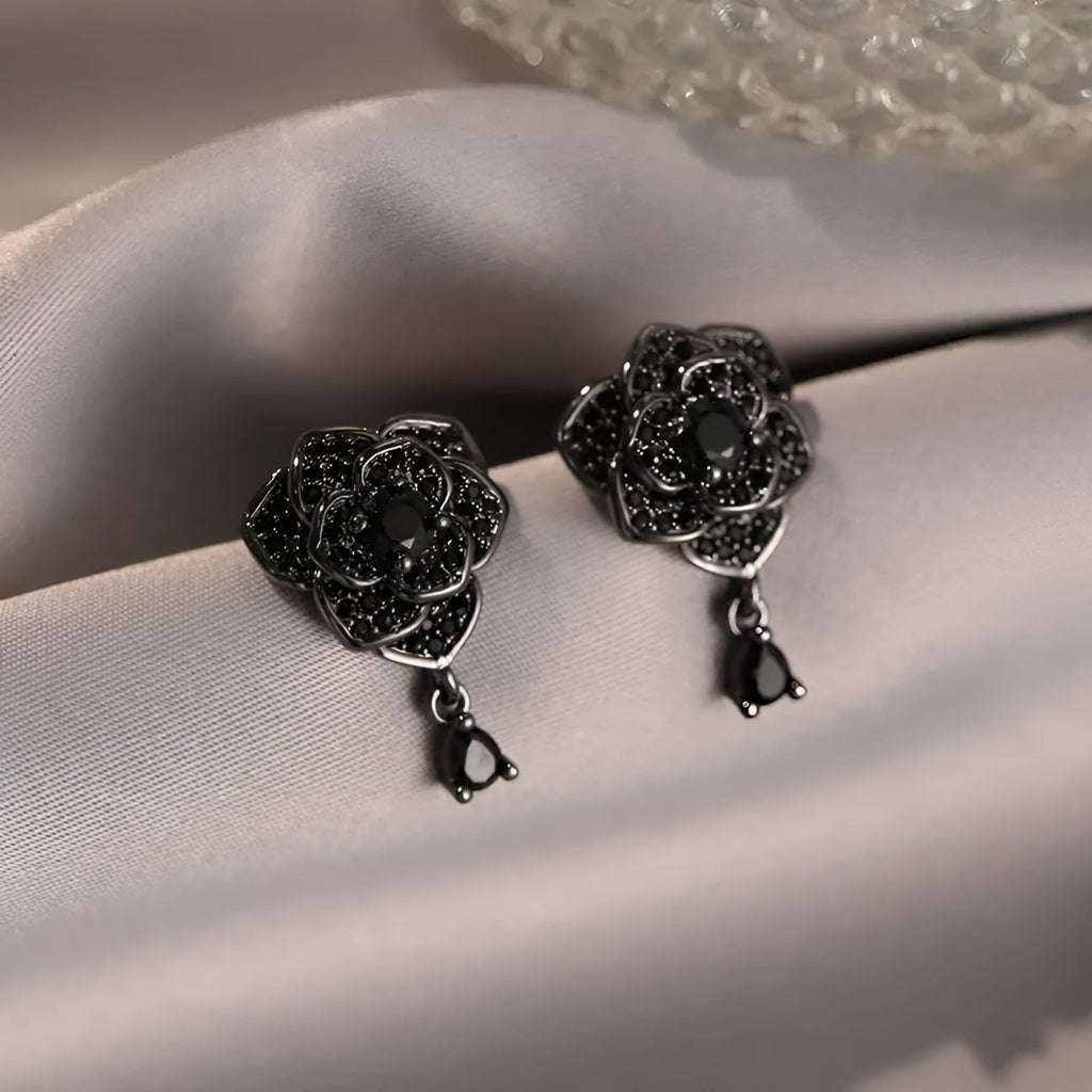 A pair of black rose zircon floral stud earrings with an 18K gold electroplated finish on copper.