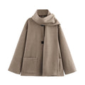 Women's long black polyester blend overcoat with a detachable artificial fur collar, showing pocket detail and street-fashion fit.