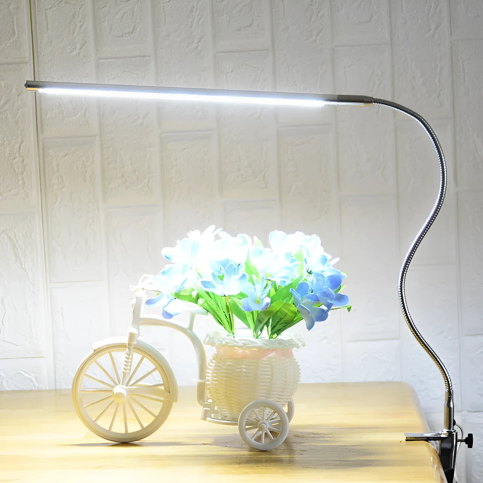 Silver long arm LED clip table lamp with USB cable, shown illuminating a nail art workspace.