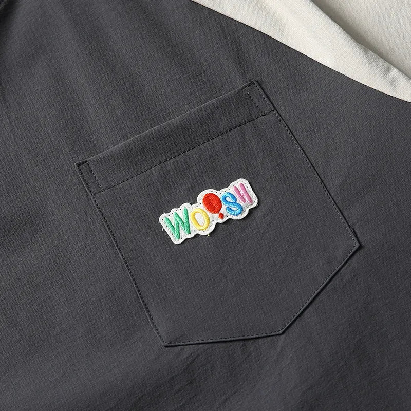 Dark grey men's loose fit t-shirt with contrasting colour raglan sleeves on a hanger.