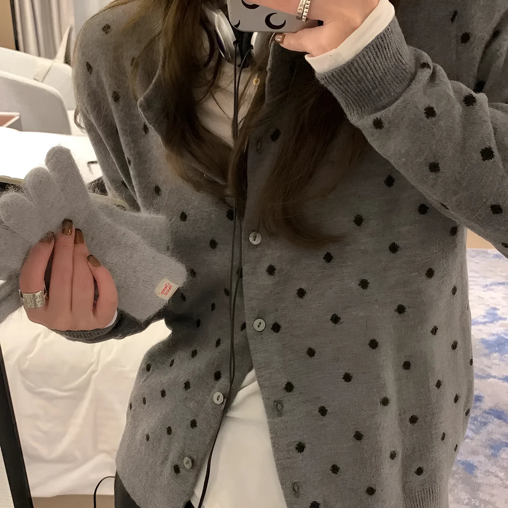 Women's grey knitted cardigan with long sleeves and white crocheted flower details on the front.