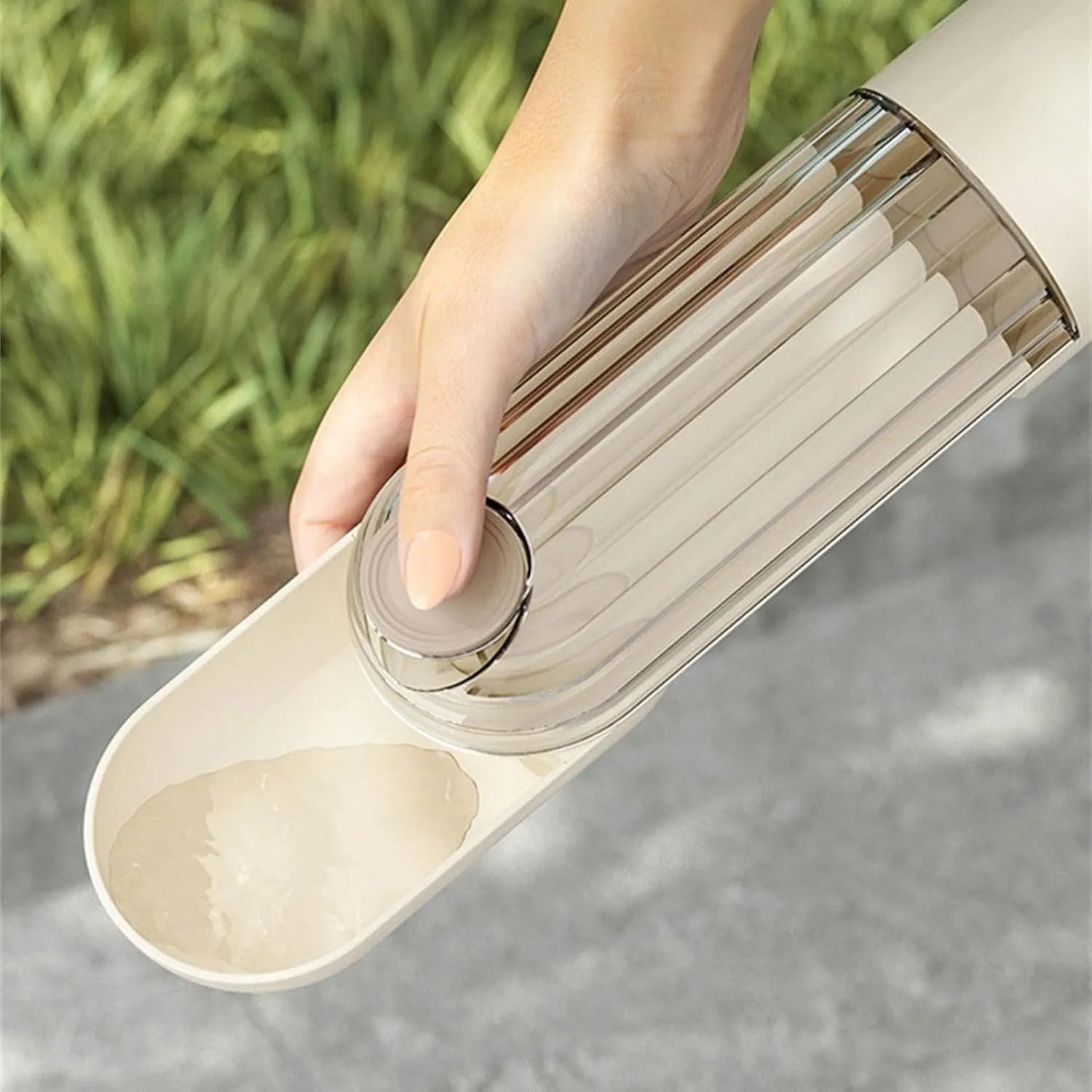 Beige and green foldable dog water bottle with food dispenser base for outdoor walking and travel.