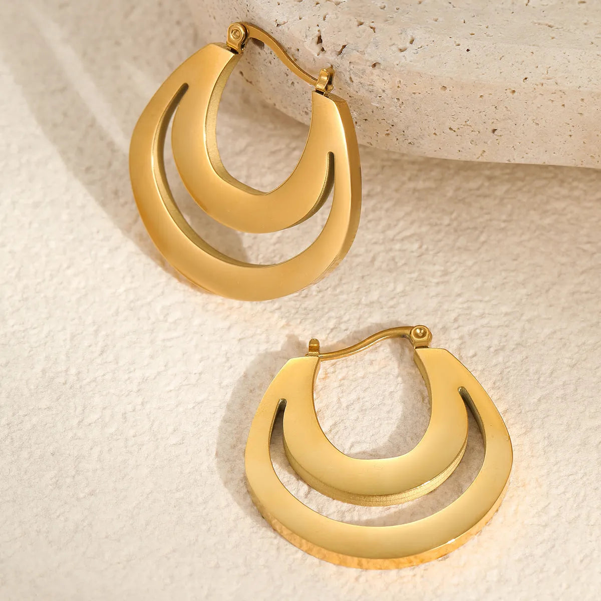 Geometric minimalist French earrings in gold and steel colours with round ring design elements