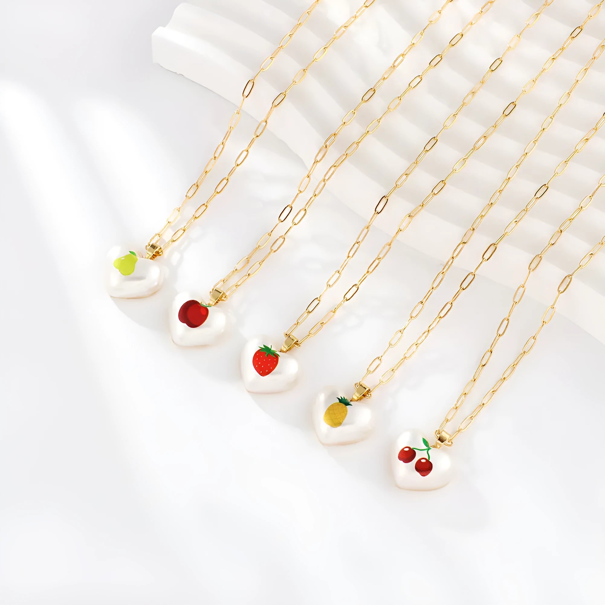 Geometric fruit pendant necklace with adjustable chain showing Apple, Cherry, Pear, Pineapple and Strawberry colour variations