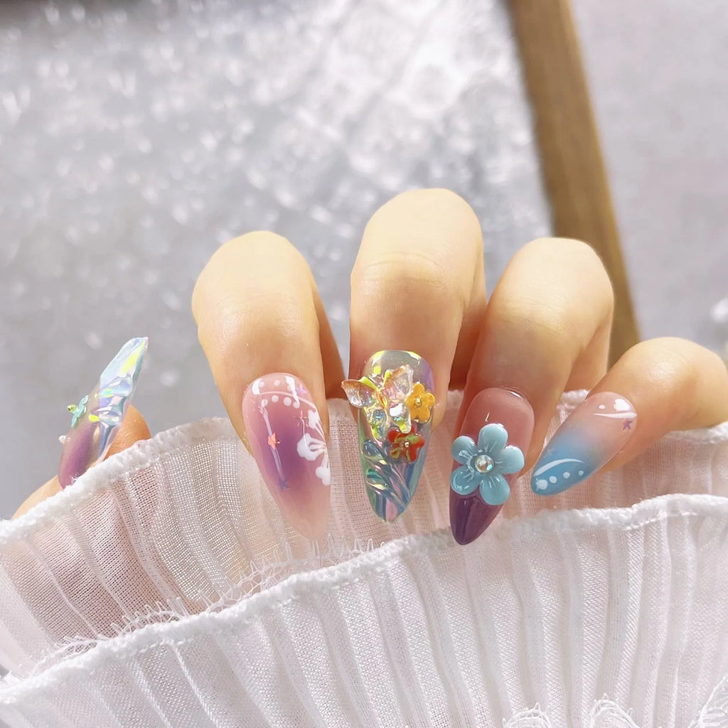 Handmade three-dimensional flower and butterfly nail art sculptures in assorted sizes on a manicure set.