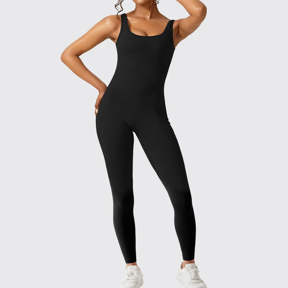 Woman wearing a sleeveless army green flare-leg jumpsuit for yoga or casual wear.