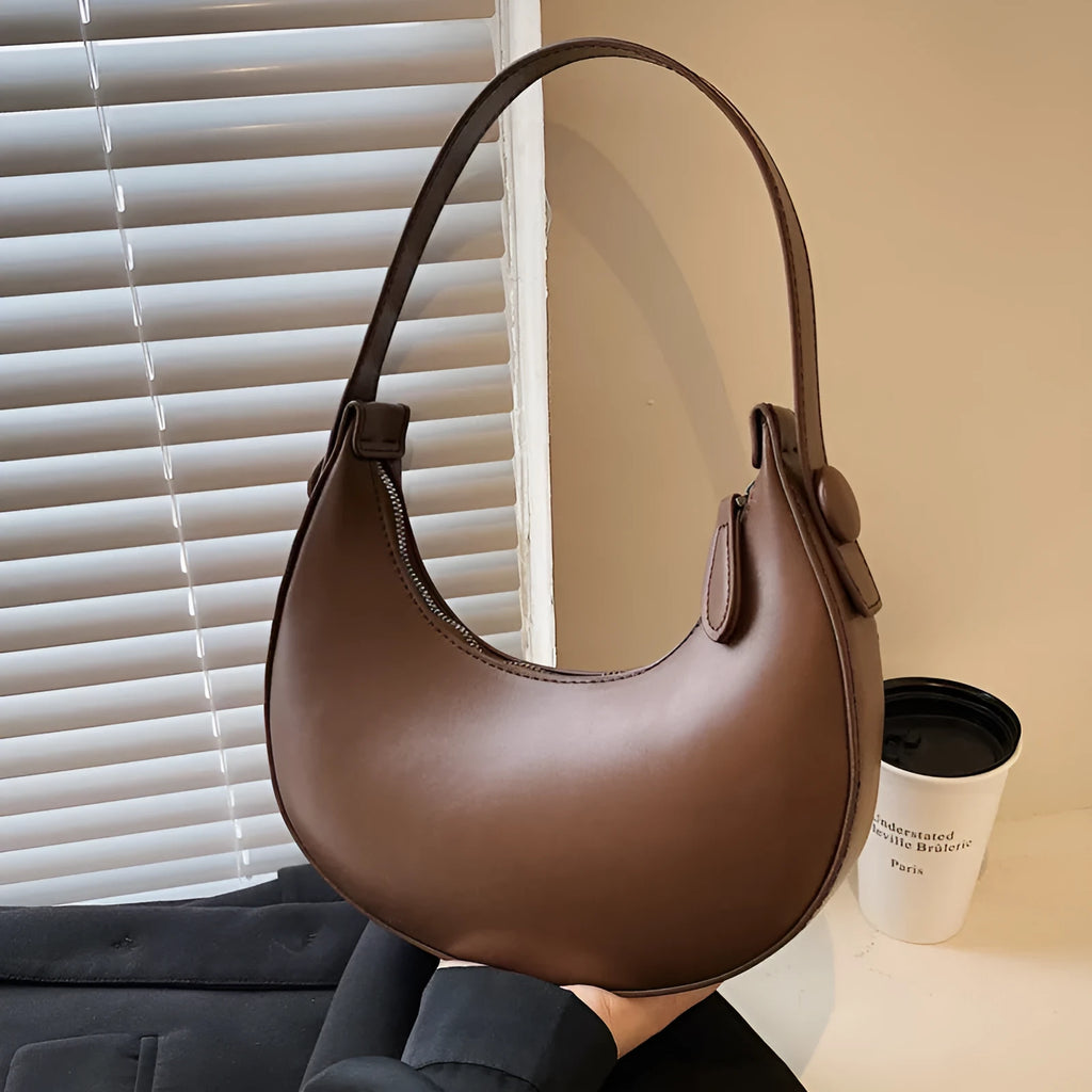 Women's retro dumpling-shaped shoulder bag in PU leather, shown in black, featuring an outer sandwich pocket.