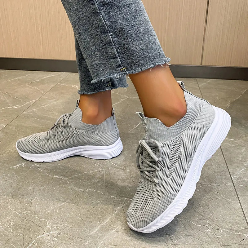 Women's low-top running shoes in creamy white with mesh and Flyknit breathable upper.