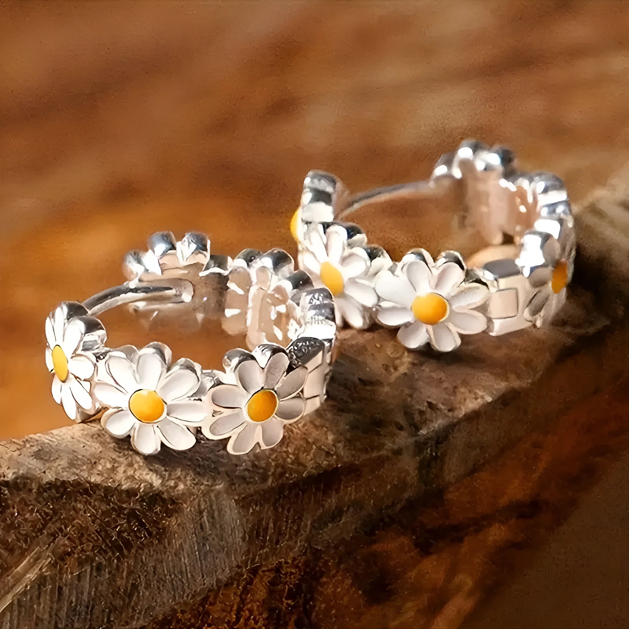 Close-up of white daisy flower ring earrings with gemstone centre on copper setting.
