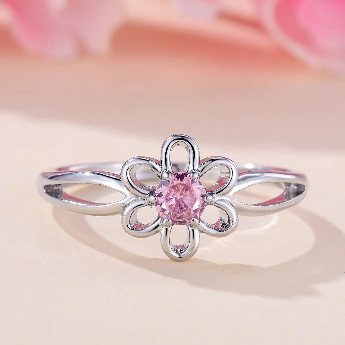 Lady's copper ring with hollowed flower design in platinum pink diamond colour showing size options