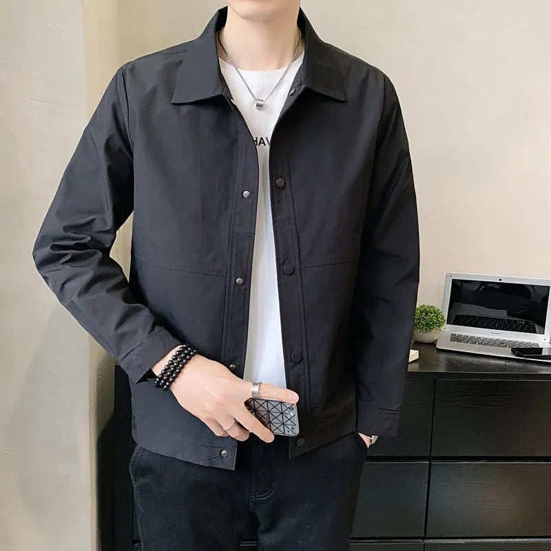 Man wearing a Korean style lightweight single-layer jacket in grey, showing front zip and long sleeves.