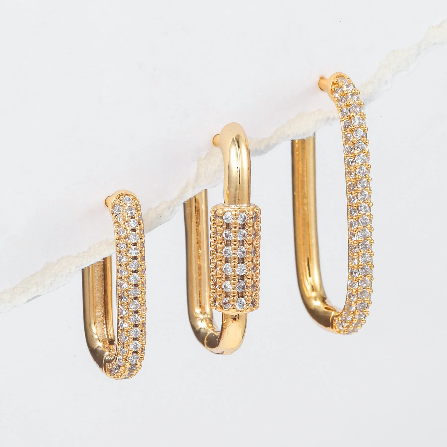 Three geometric copper ear clips with micro inlaid zircon detailing in gold and white finishes