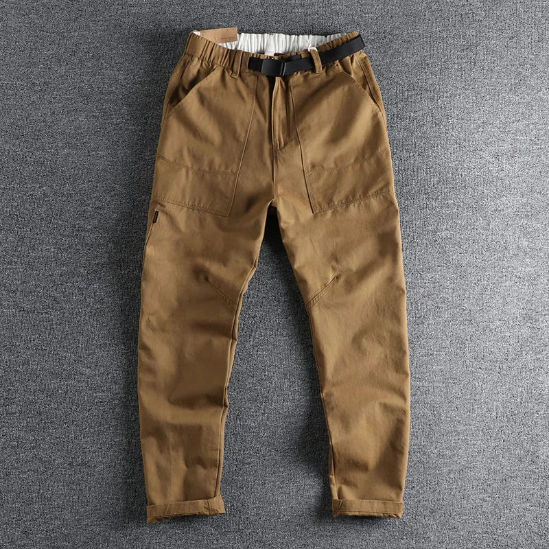 Men's khaki cotton work trousers with a matching N I buckle belt, showing three-dimensional cutting and a zipper fly.