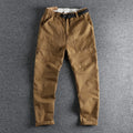 Men's khaki cotton work trousers with a matching N I buckle belt, showing three-dimensional cutting and a zipper fly.