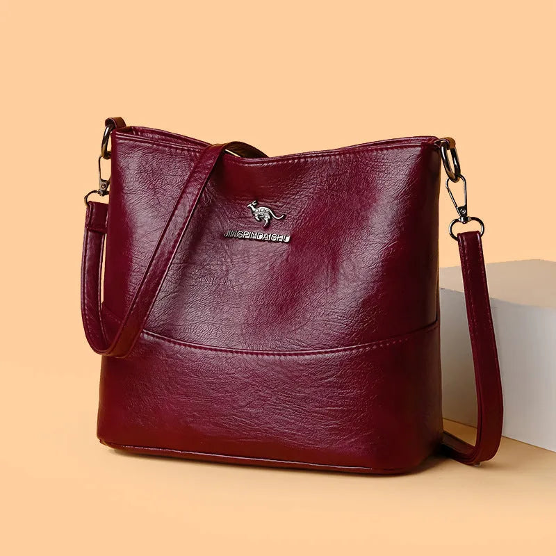 Women's black soft leather bucket-style shoulder bag with minimalist design and visible stitching