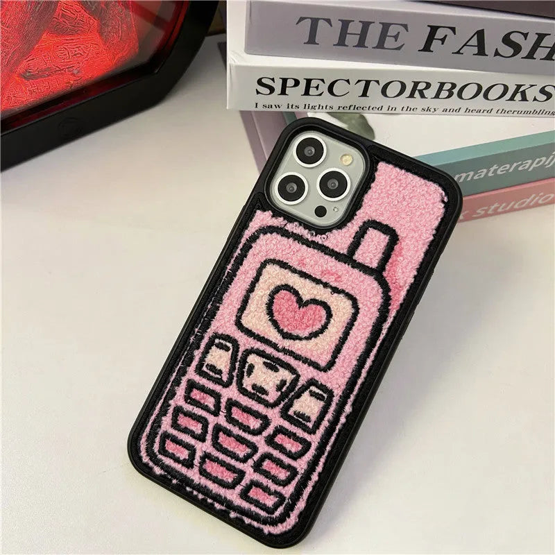 Pink towel embroidered soft TPU back cover case for iPhone models on a table.