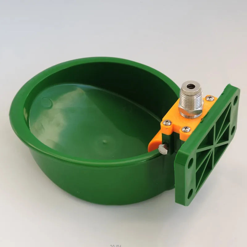Green plastic automatic water drink bowl for pigs and sheep on a farm.