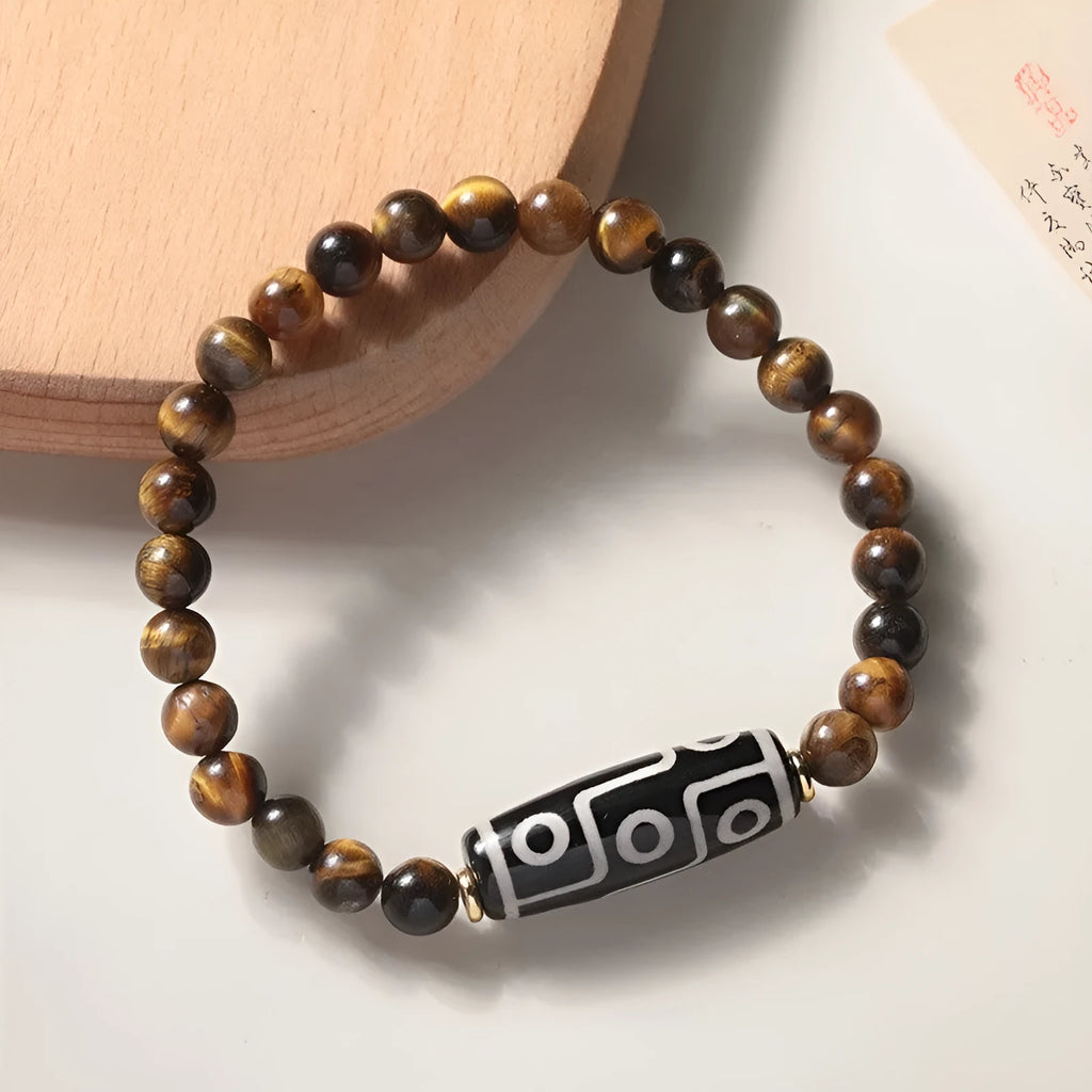 Single circle tigereye Dzi bead Buddhist mala bracelet shown on a wrist.