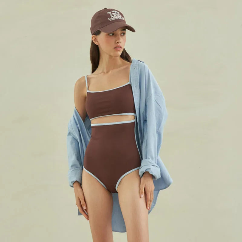 Brown triangle top one-piece swimsuit for women on a hanger.
