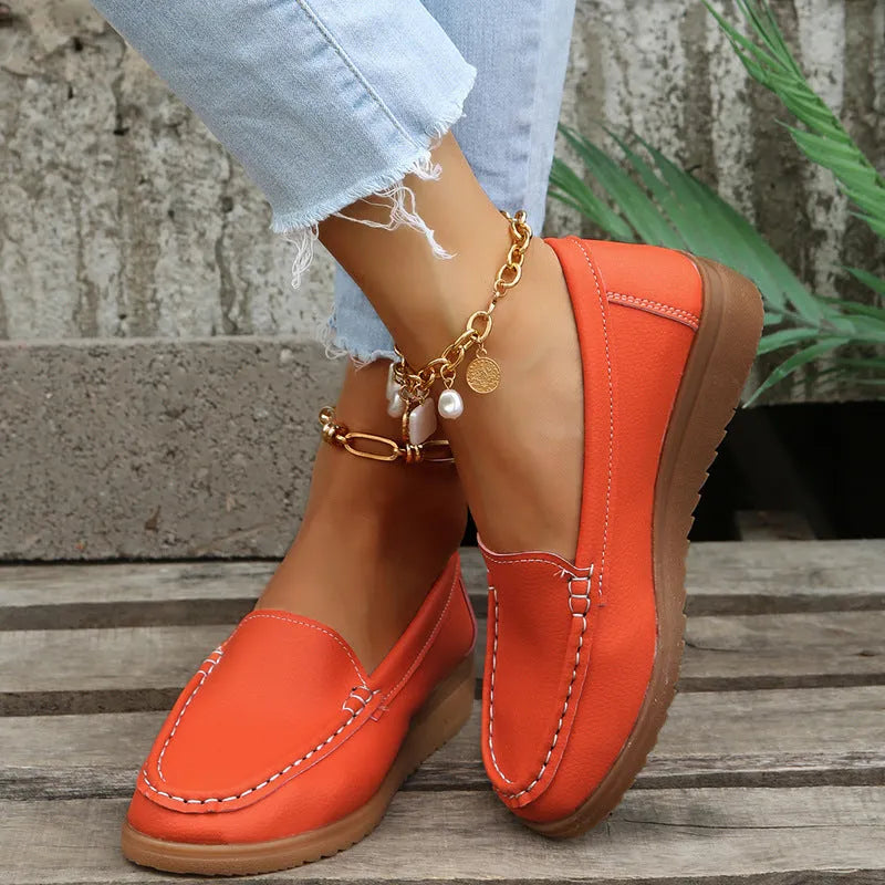 Women's white PU leather slip-on loafer flats with round toe and rubber sole on a plain background.
