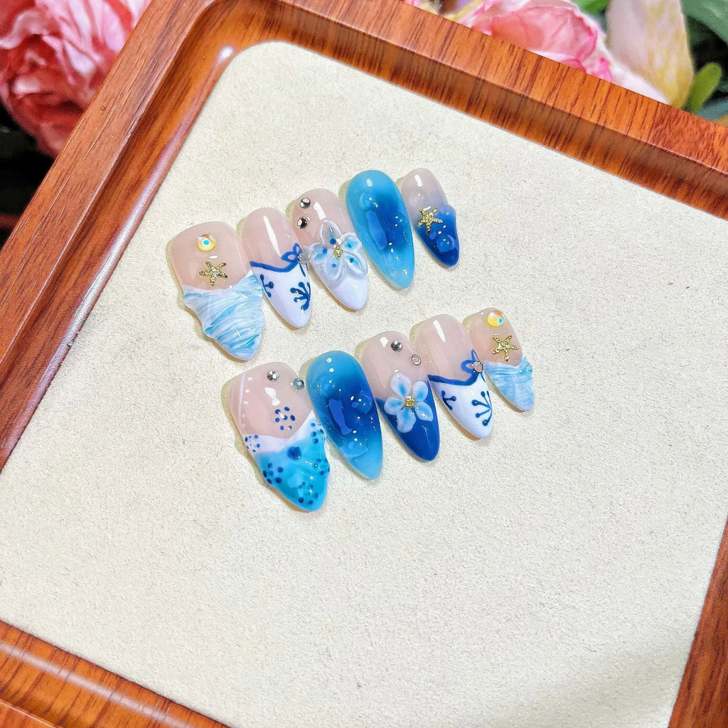 Blue summer ice transparent fake nails with hand-painted carved design, showing four size categories XS S M L