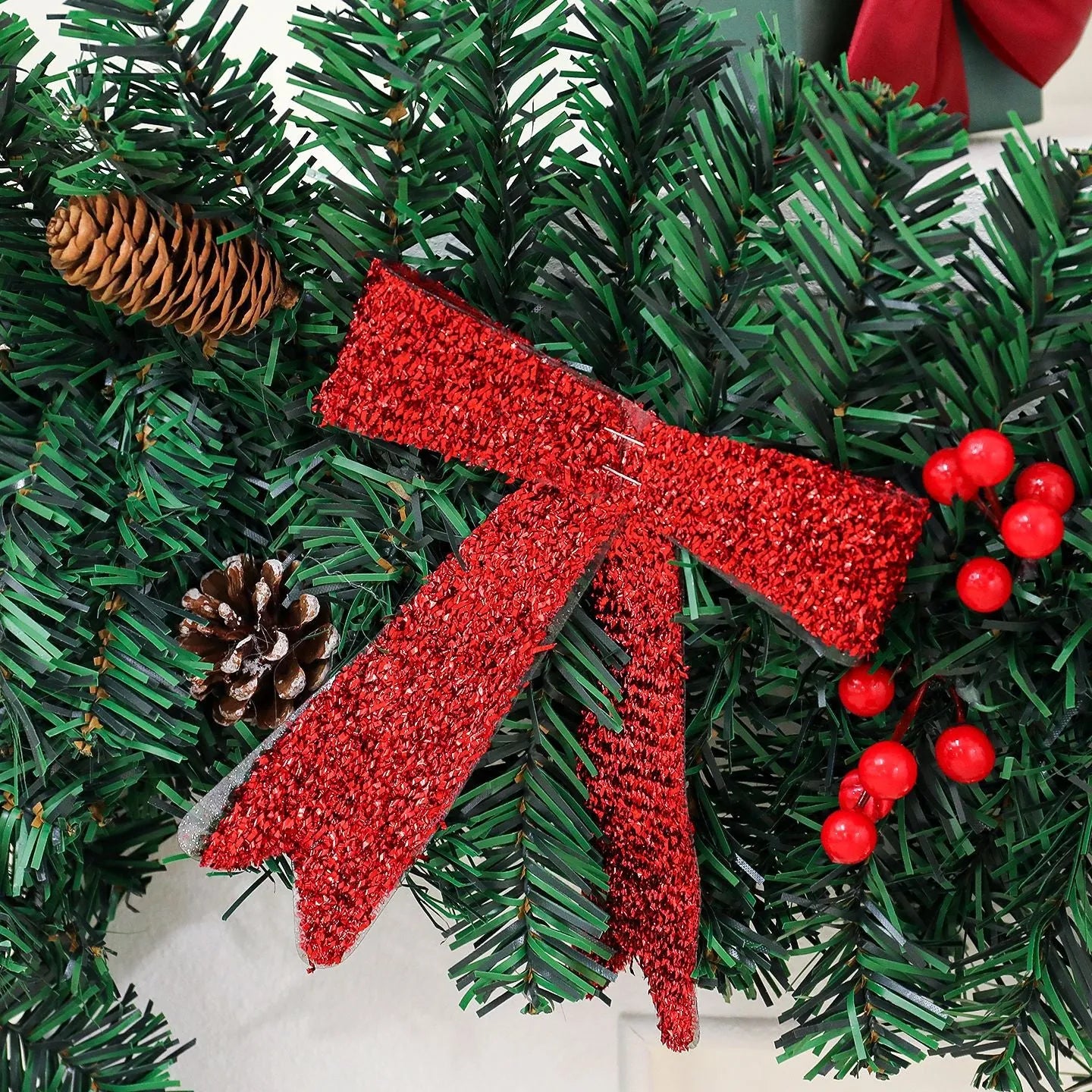 European-style rattan Christmas cane decoration with pine cone and red bow, approximately one metre tall.
