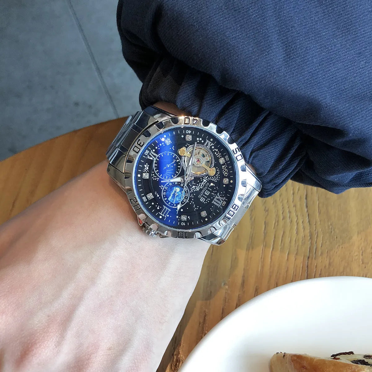 Silver case men's automatic watch with black starry dial, luminous markers, and leather strap