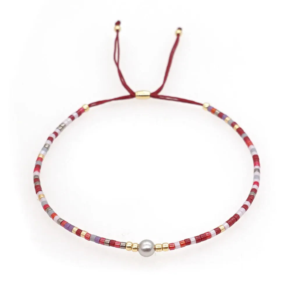 Handmade bohemian bracelet with semi-precious stone and colourful glass beads on a wrist.