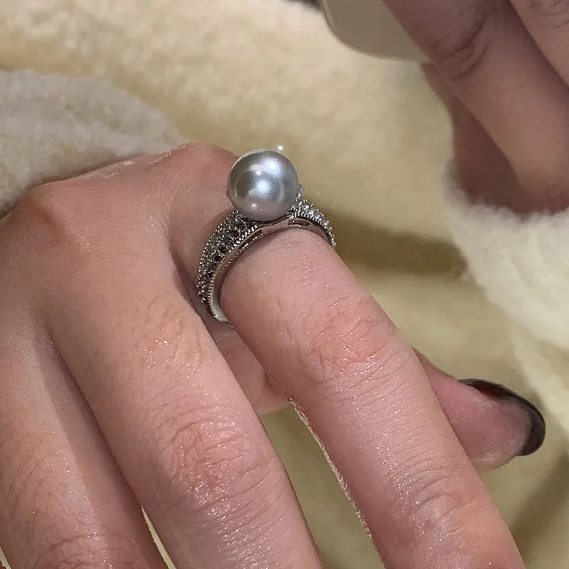 Adjustable geometric copper open finger ring in black pearl colour on grey background