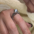 Adjustable geometric copper open finger ring in black pearl colour on grey background