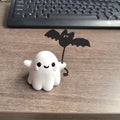 Mini resin statue of a ghost walking a dog and holding a bat, a Halloween ornament.