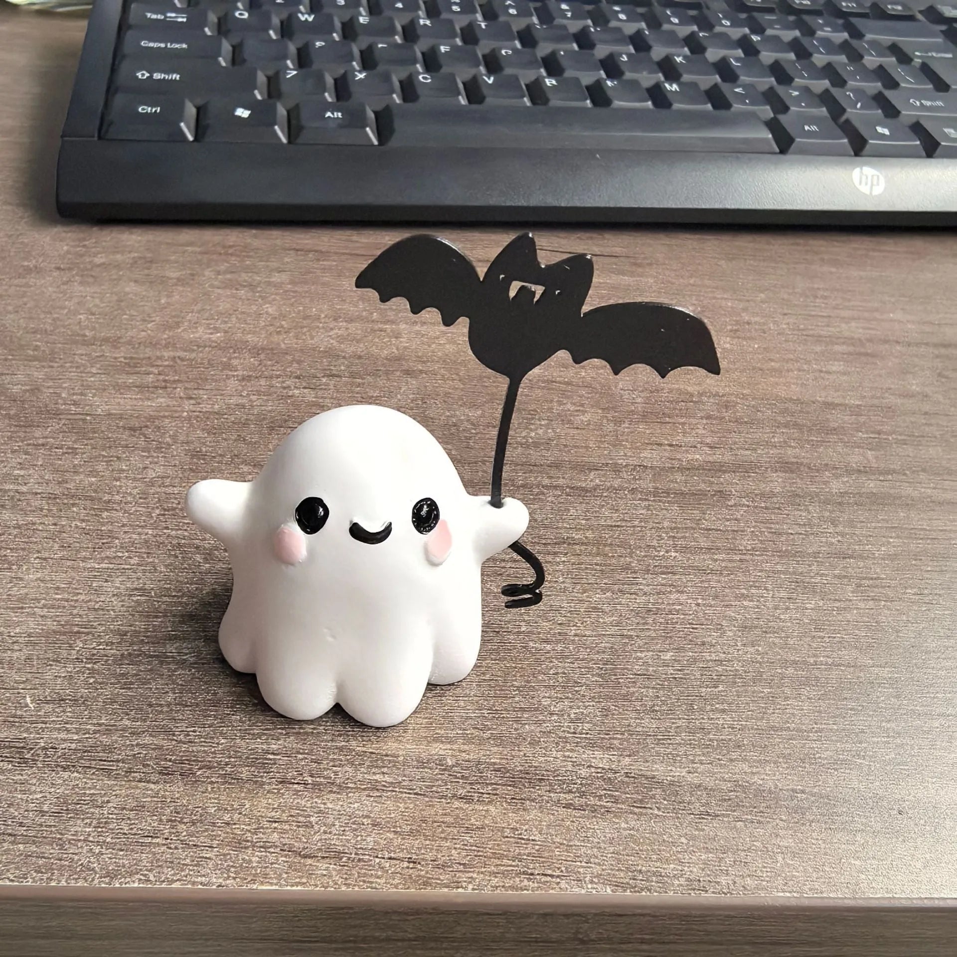 Mini resin statue of a ghost walking a dog and holding a bat, a Halloween ornament.