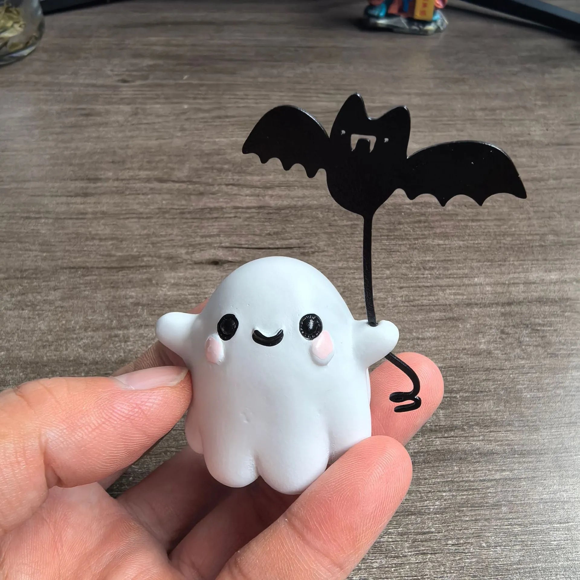 Mini resin statue of a ghost walking a dog and holding a bat, a Halloween ornament.
