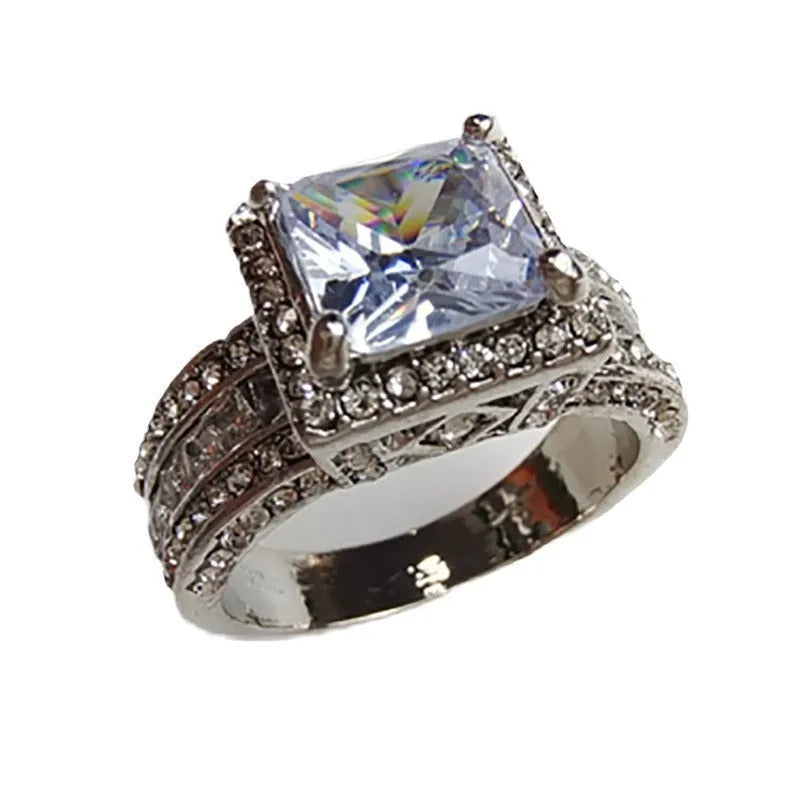 Geometric silver-coloured women's ring with round design elements on a finger, shown in gold and white colour options.
