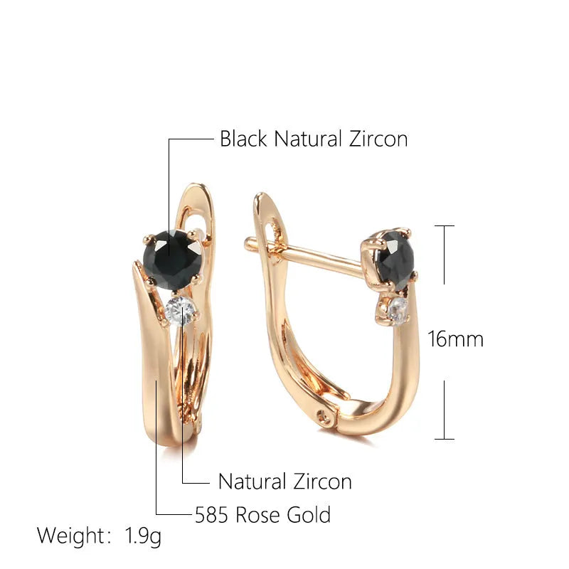 Gold geometric drop earrings with black agate stone inlay on a model's ear