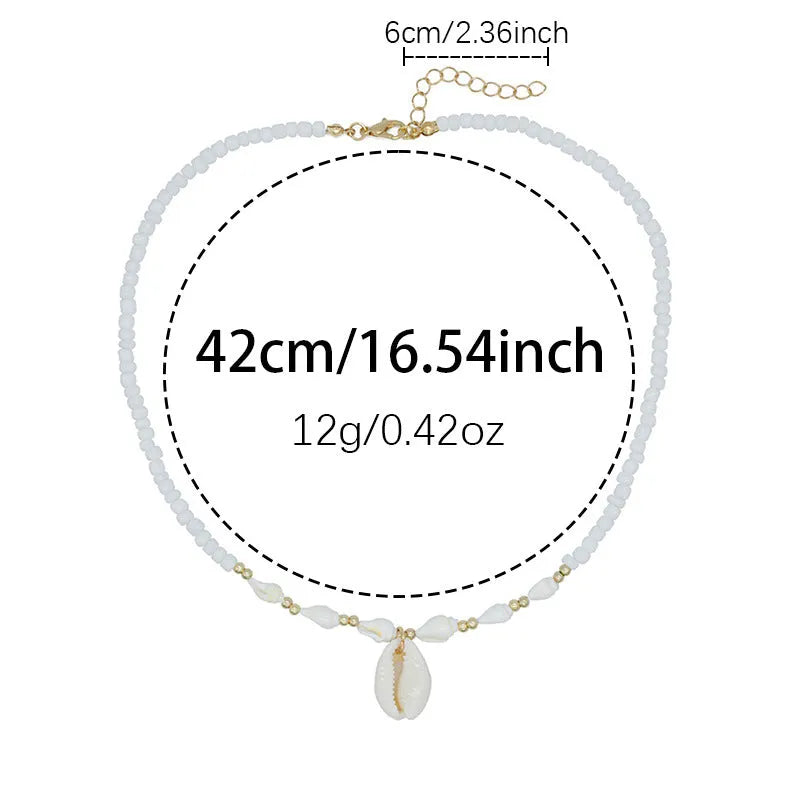 Close-up of a white conch shell necklace pendant made from Mother Pearl on a silver-toned chain.