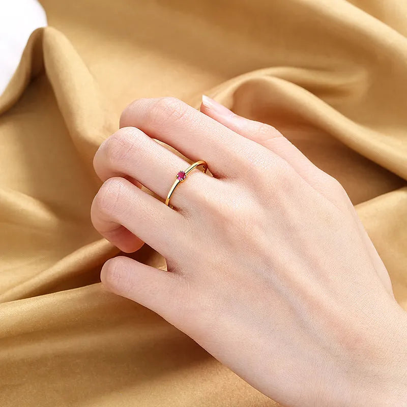 A simple copper ring for women with a single diamond on a fine circle band, shown in blue, green, red, or white.