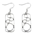 A pair of antique silver geometric earrings showing an irregular square shape inside a round ring.