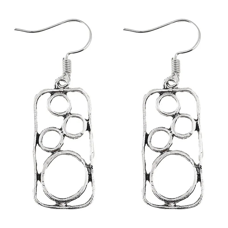 A pair of antique silver geometric earrings showing an irregular square shape inside a round ring.
