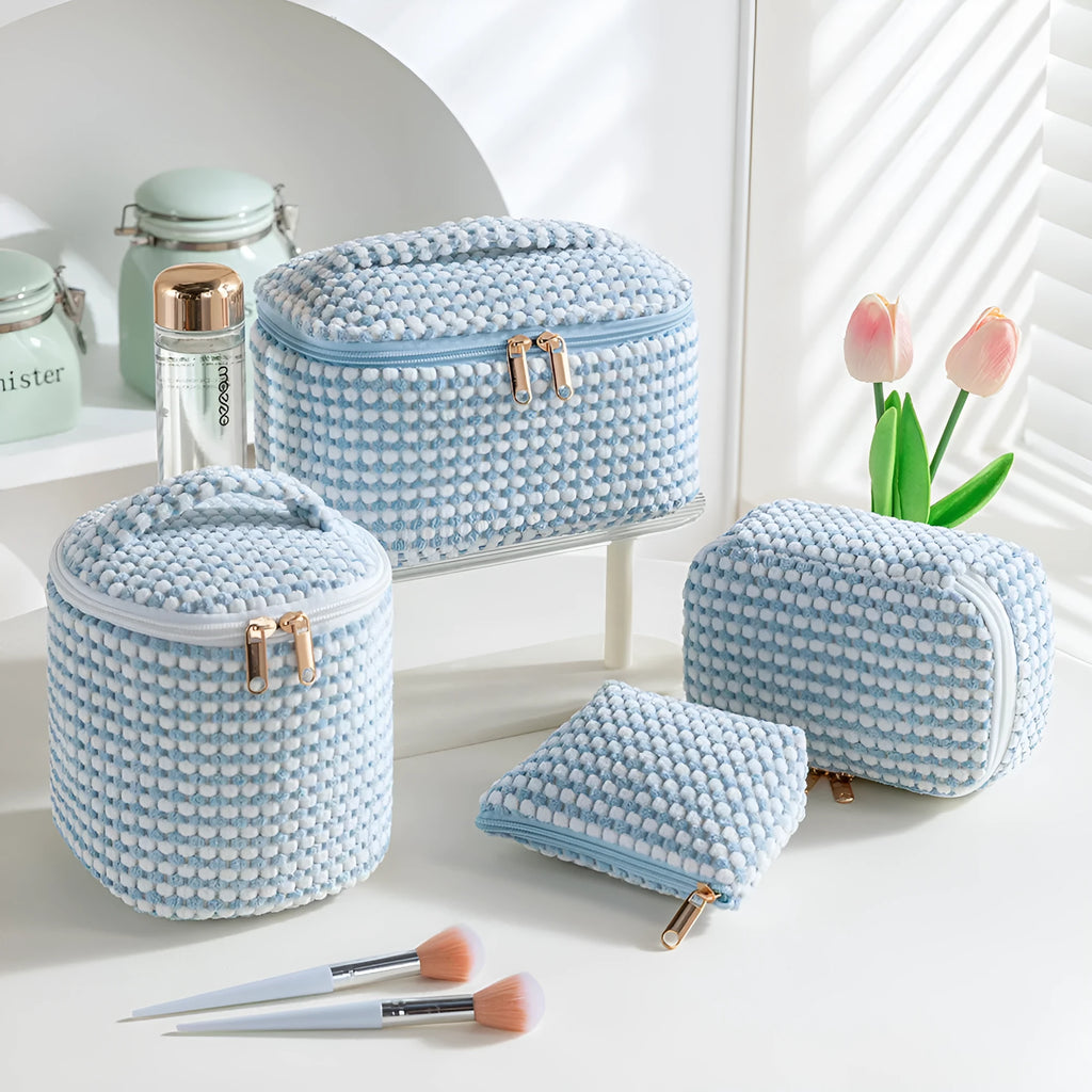 Four cube makeup bags in blue with dots pattern arranged as travel set