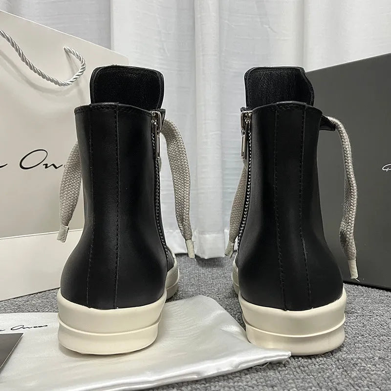 Black high-top leather sneakers with side zipper and round toe design on a white background