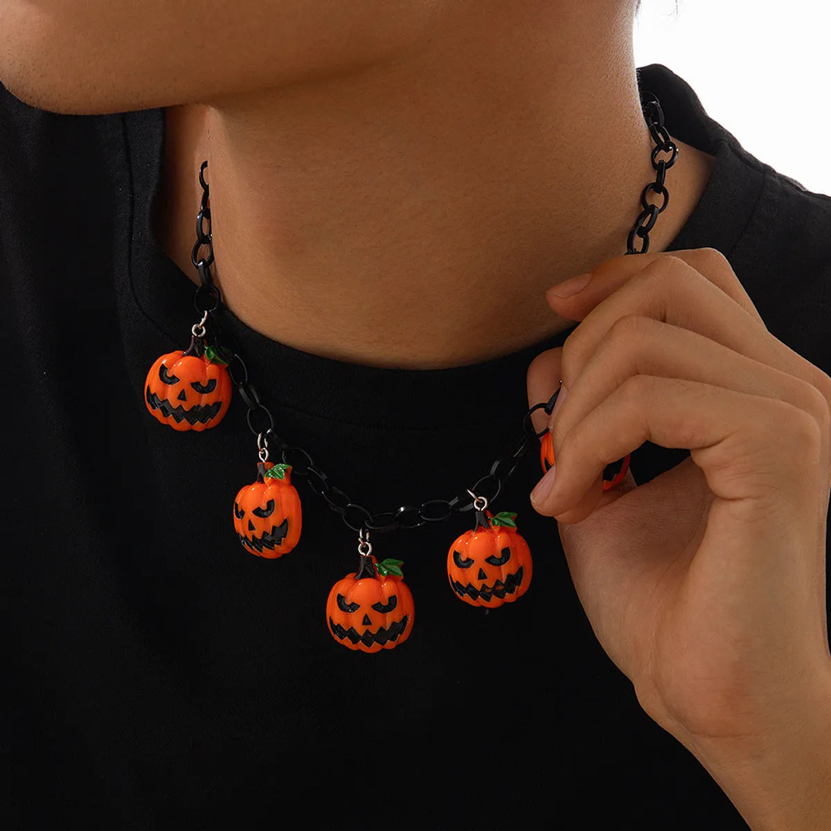 Colourful Halloween necklace showing a cartoon ghost pumpkin pendant on a chain.