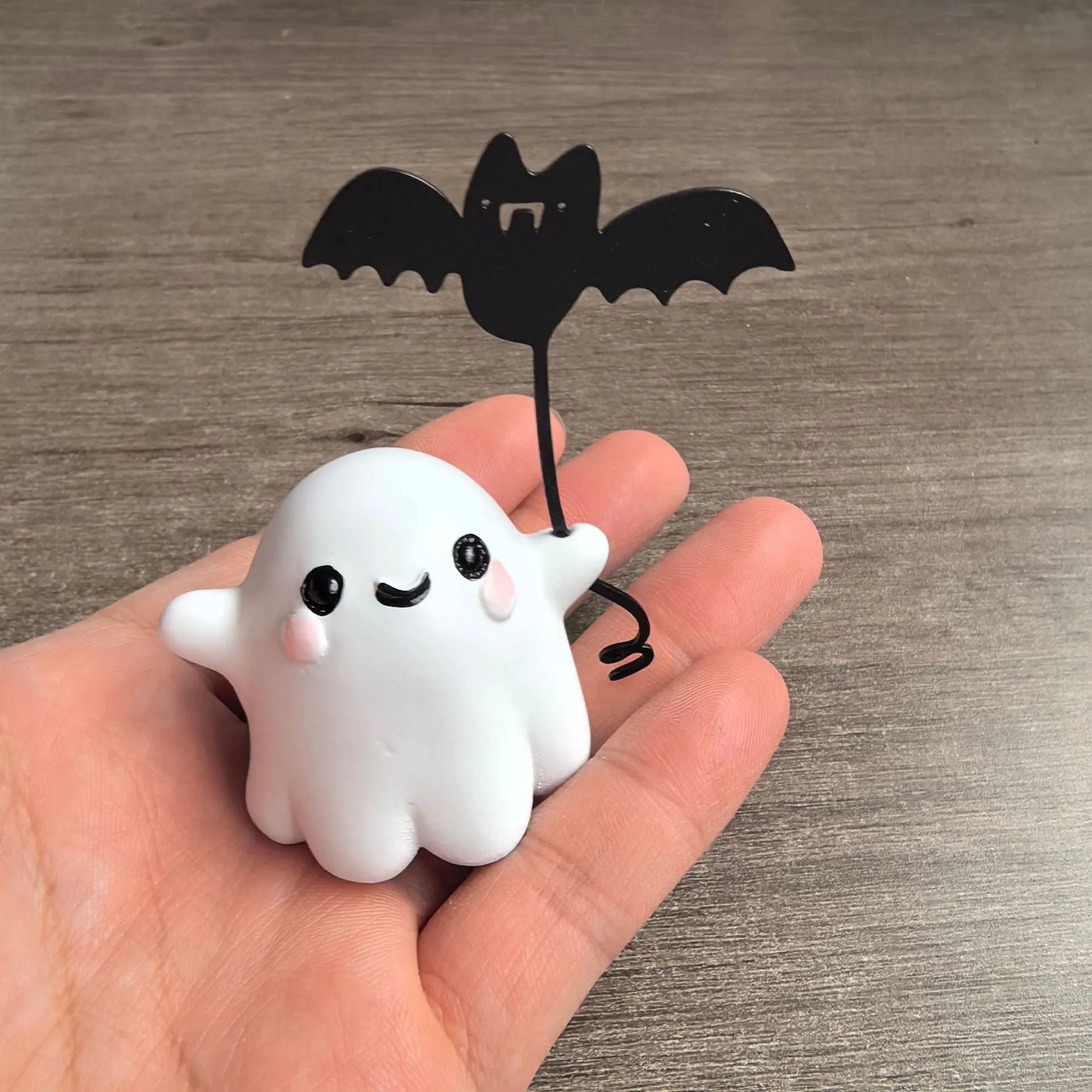 Mini resin statue of a ghost walking a dog and holding a bat, a Halloween ornament.